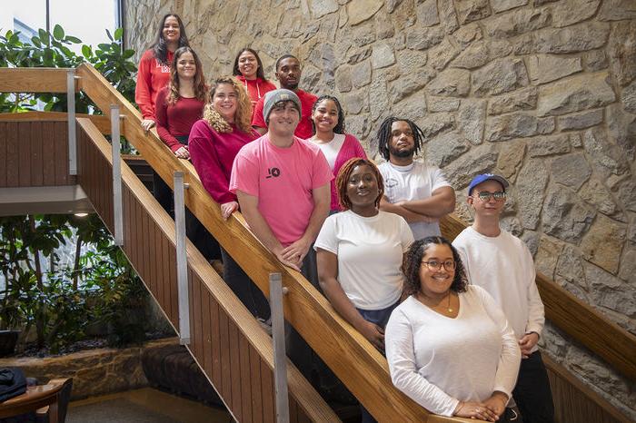 Resident Assistants for The Woods stand on the Perkins Student Center stairs